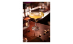 Ein gelber Cocktail in einem transparenten Cocktailglas Echo, 11 cm hoch, garniert mit Limette, auf einer nussbestreuten Bar.
