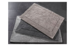 Drei Casa Nova Badteppich Cleveland 60x90 cm Matten in Grau und Beige auf dunklem Fliesenbelag.