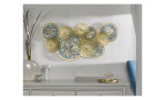 Casa Nova Metall-Wanddeko Kreise in Gold und Blau über weißem Sideboard mit Deko und blauem Stuhl.