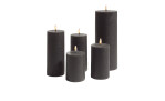 Fünf leuchtende LED-Echtwachskerzen 15 cm schwarzer Stumpenkerzen schaffen eine stilvolle Grau Dekoration auf weißem Hintergrund.