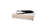 Das Schlafsofa „Feye“ in Beige mit einer schwarz-weißen, gefalteten Decke darauf, vor einem schlichten weißen Hintergrund.
