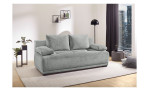 Das Schlafsofa „Delia“ in Hellgrau auf einem beigen Teppich in einem modernen Wohnzimmer mit Blick auf die Stadt.