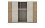 Schwebetürenschrank Silvio aus Holzwerkstoff in Eiche Artisan mit einer Absetzung im Champanger Farbglas. Geöffnete ANsicht.