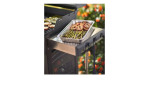 Weber Alu-Tropfschalen 5 Stück auf einem BBQ-Seitenregal halten gegrilltes Gemüse und Fleisch, im Hintergrund sind Blumen zu sehen.
