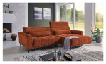 Komfort-Wohnlandschaft Lilly in einem orangefarbenen Cordstoff mit zwei Zierkissen und gezeigter Funktionen. Auf einem dekorierten Hintergrund.