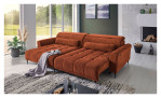 Komfort-Wohnlandschaft Lilly in einem orangefarbenen Cordstoff mit zwei Zierkissen und gezeigter Funktion. Auf einem dekorierten Hintergrund.