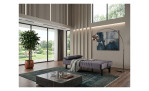 Modernes Wohnzimmer mit dem Schlafsofa „Ruben“, einem Topfbaum, großen Fenstern, die für mehr Weite sorgen, einem Teppich, einem Tisch und abstrakter Wandkunst.