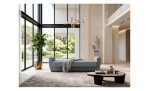 Modernes Wohnzimmer mit großen Fenstern, einem 3-Sitzer-Sofa „Aiden“, einem abstrakten Teppich und einer Skulptur; helle und luftige Atmosphäre.