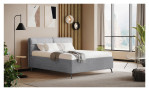 Modernes Schlafzimmer mit dem Vito Komfort-Polsterbett „Nivora“, neutraler Einrichtung, großen Fenstern, Pflanzen und abstrakter Wandkunst.